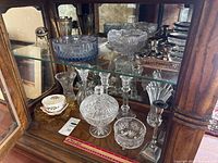 Overall view of crystal pieces and EP brass candlesticks in cabinet
