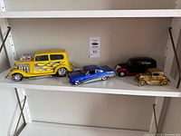 Four model cars on shelf