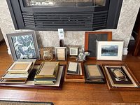 Group of assorted frames laid out below fireplace