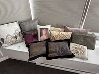 Group shot of all ten pillows displayed on bench