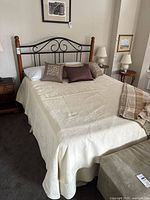 Full view of queen bed with frame, mattress and bedding