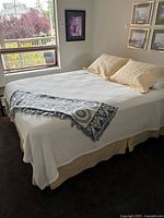 Full view of queen bed with coverlet, throw blanket and shams