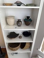 Shelving view showing all ceramic pieces and two wicker baskets