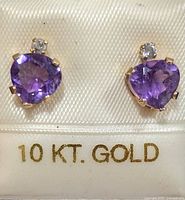 Front view of amethyst and diamond stud earrings on card