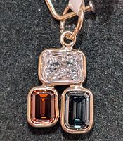 Front view of pendant showing three stones and gold setting