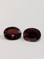 Pair of oval faceted deep red garnet gemstones