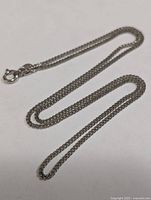 Full view of silver chain laid out showing length and link style