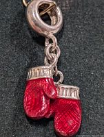 Close-up of pendant front showing red enamel boxing gloves and silver bail