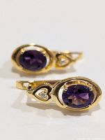 Close view of both earrings showing amethyst stones, clear accent stones and lever-back fittings