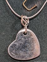 Close-up of heart pendant on silver snake chain