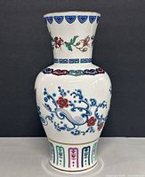 Front view of porcelain vase showing scroll and floral enamelling