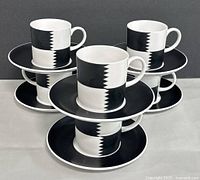 Six cups stacked on matching saucers showing full set front view