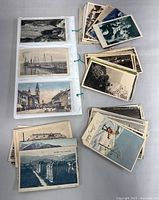 Overall view showing binder with inserted postcards and four sorted stacks
