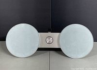 Front view showing full BeoSound 8 with both speaker grilles and central panel