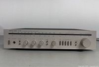 Front view of Harman Kardon HK385i receiver showing controls and tuning scale
