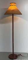 Full view of teak floor lamp illuminated