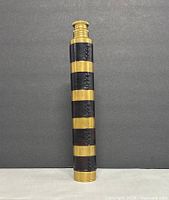 Full length view of closed telescope upright against backdrop