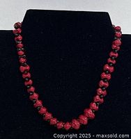 Full view of necklace on display bust showing red and black beads
