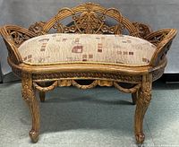 Front view of carved wood French style settee showing full frame and upholstery