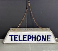 Front view showing full sign lit with chain attached