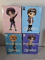 Front view of four boxed Q Posket figures stacked two by two