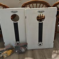 Front view of both cornhole boards with bean bags in plastic bags