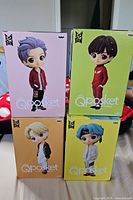 Four Q Posket boxes stacked showing front art