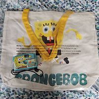 Canvas tote with Spongebob graphic, yellow handles, blue cardholder visible
