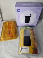 Motorola StarTAC boxed phone with two packaged accessories