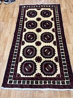 Full view of Baluchi rug on floor showing overall design