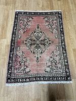 Full view of pink Hamadan rug with floral medallion and border