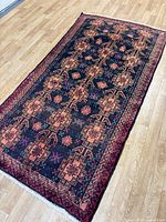 Full view of Baluchi wool rug showing size, pattern and borders