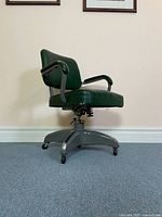 Side view showing entire chair, green vinyl upholstery, metal base, spring mechanism