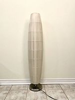 Full view unlit floor lamp against wall