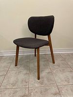 Front view of chair showing fabric seat and back, wooden legs