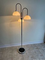 Lamp illuminated, showing three lit dome shades and chrome stand