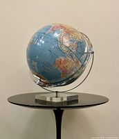 Full view of globe on Lucite base side angle
