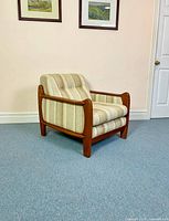 Front angled view of teak and tweed armchair
