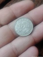 Reverse of 1930 Canada 5 Cent showing denomination and maple leaves