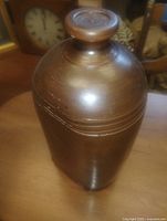 Side view of brown glazed stoneware foot warmer showing overall shape and stopper