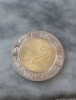 Reverse side with $2 denomination, year 2021, Aztec motif outer ring