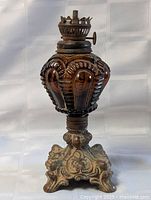 Full view showing amber glass font, metal burner, ornate metal base