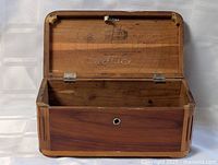 Lid open showing interior branding, hinges, cedar wood grain