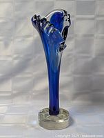 Full view of cobalt blue art glass bud vase on clear base