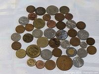 Group shot of entire coin lot spread on white cloth, shows quantity and range of sizes