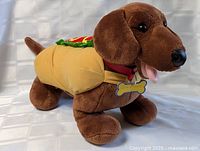 Left front view of plush dachshund in hot dog costume