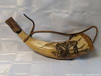 Full view of horn powder flask showing shape, stopper and strap