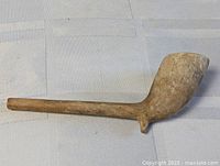 Full view of clay pipe on fabric background