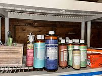 Shelf view showing multiple castile soap bottles, dental kit box