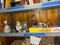 Shelf showing assortment of figurines, nesting dolls and box of small figures